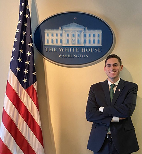 Jacob Whatley standing next to a sign that says The White House Washington