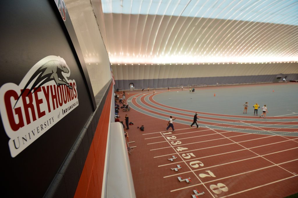 Wide shot of Indoor track facility with Greyhound logo at forefront
